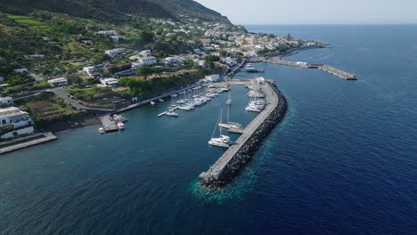 4k aerial slow orbit of salina marina, with salina town in the background, italy