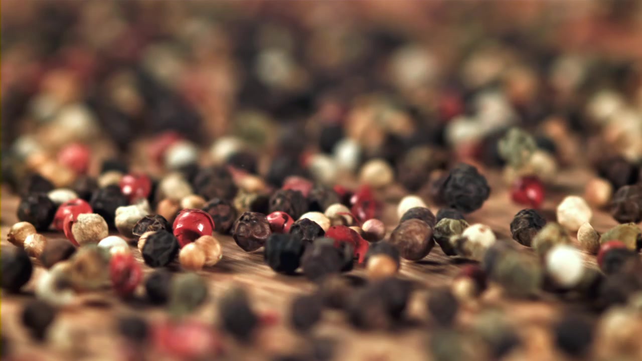 Colorful Peppercorns Falling in Slow Motion on Wooden Surface