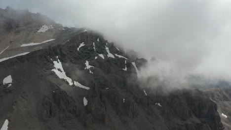 Aerial-of-rocky-mountain-top-covered-in-thick-clouds