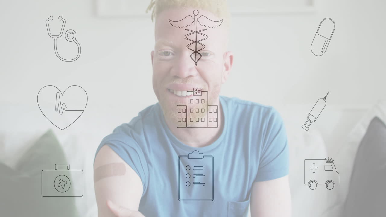 man sitting on couch, displaying bandage on upper arm, with animated health icons floating around