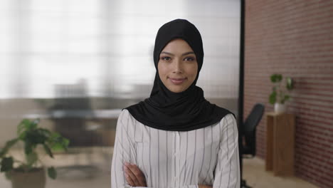 portrait of young muslim business woman looking serious at camera arms crossed in office workspace