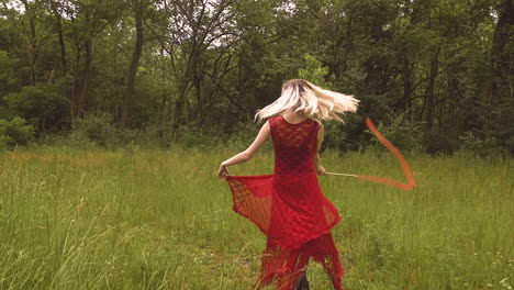 cute young woman with blonde hair dances through the meadows