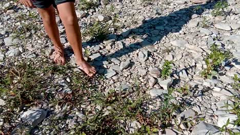 niño descalzo caminando a través de un lecho de río seco