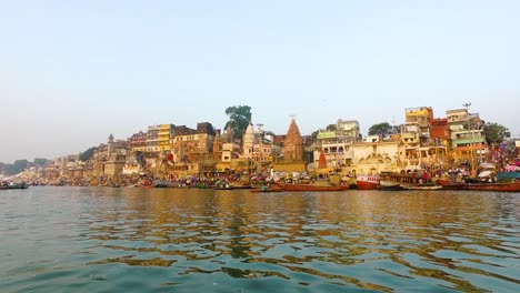 river ganges in varanasi with buildings lit in the morning sunrise in india