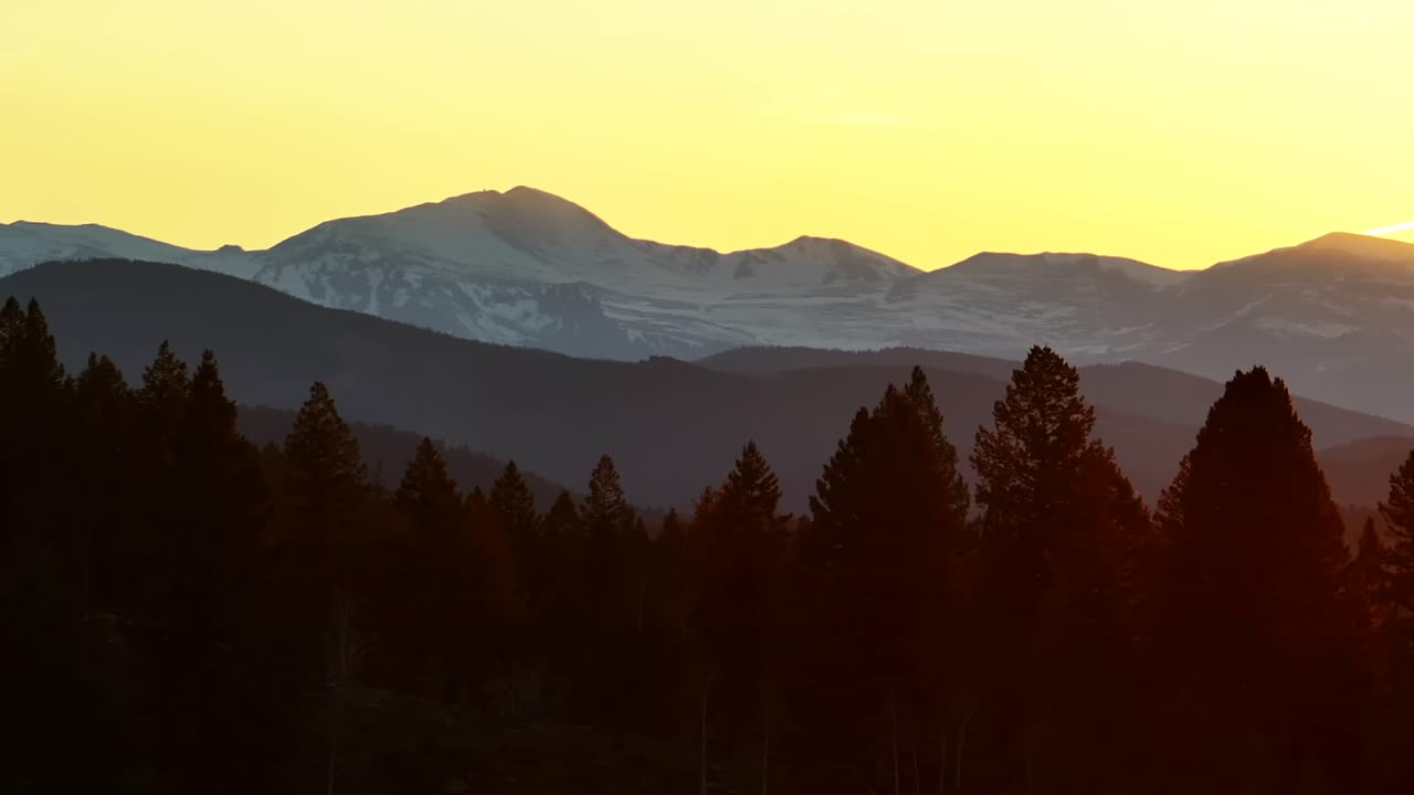 Mount Blue Sky front range Mt Evans peak aerial drone Evergreen Colorado scenic bypass golden hour sunset sun flare yellow sky Rocky Mountains layers Arapaho National Forest spring summer circle right