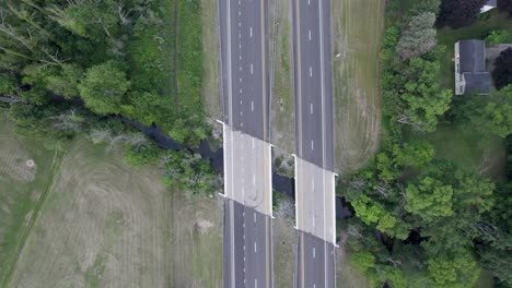 Vista-Aérea-De-Drones-A-Vista-De-Pájaro-Sobre-Pequeños-Puentes-Sobre-Un-Estrecho-Canal-De-Agua-Durante-El-Día