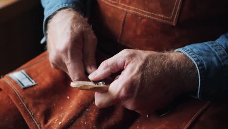 close up of artisan craftsman carving wooden spoon