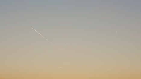 aeroplane leaves trail flying at sunset