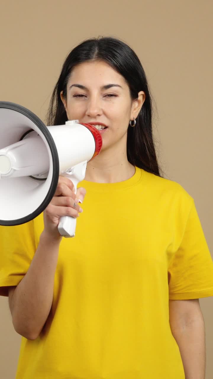 Young woman shouting aggressively into a megaphone