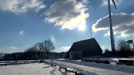 Winterlandschaft-Mit-Kahlen-Bäumen,-Haus-Und-Windmühle-Tagsüber-–-Nach-Oben-Geneigte-Aufnahme