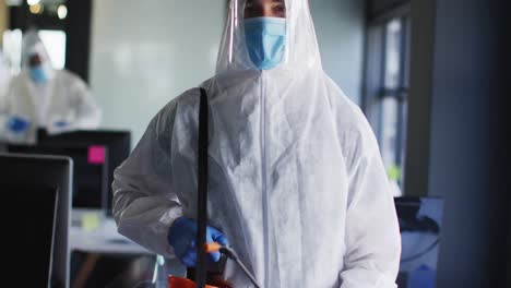 retrato de un trabajador de la salud con ropa de protección y máscara facial en una oficina moderna