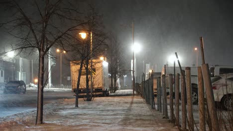 Snowy-night-in-Saint-Jean-sur-Richelieu-with-street-lights-and-parked-cars,-Quebec,-Canada,-wide-shot