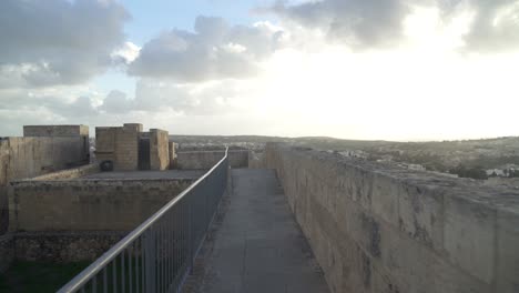 defensive cittadella fortress wall leading to guard tower on sunny winter day in gozo island