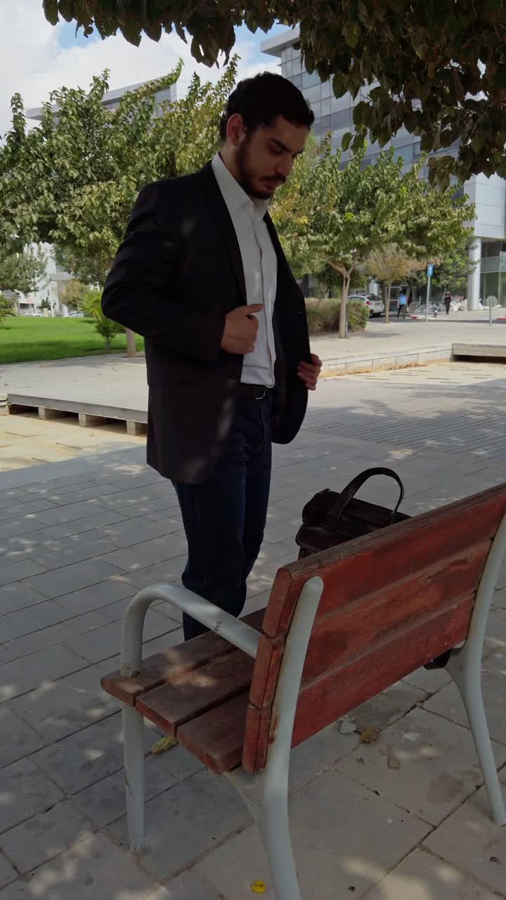 Businessman Settling on a Park Bench for a Rest