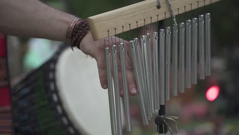 slow motion close up view of man hand playing bar chimes during a religious outdoor event in latin america