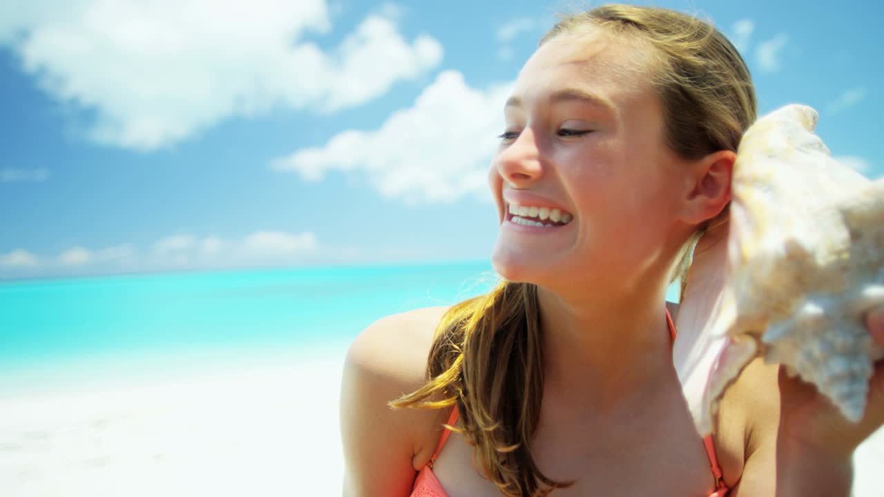 Ritratto di ragazza sulla spiaggia con una conchiglia.