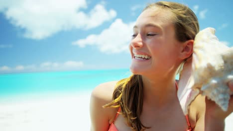 portrait of girl on beach holding conch shell