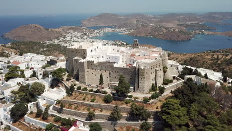 greece, patmos island, drone footage of the holly castle monastery surrounded by the traditional white houses and the beautiful aegean sea. picturesque island with beautiful landscapes and buildings.