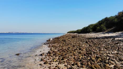Drone flying low over the pebbles on the beach