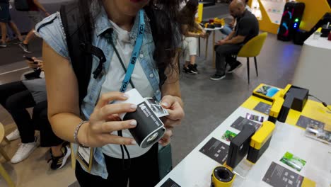 woman shows off new portable instant photo printer at tech trade show
