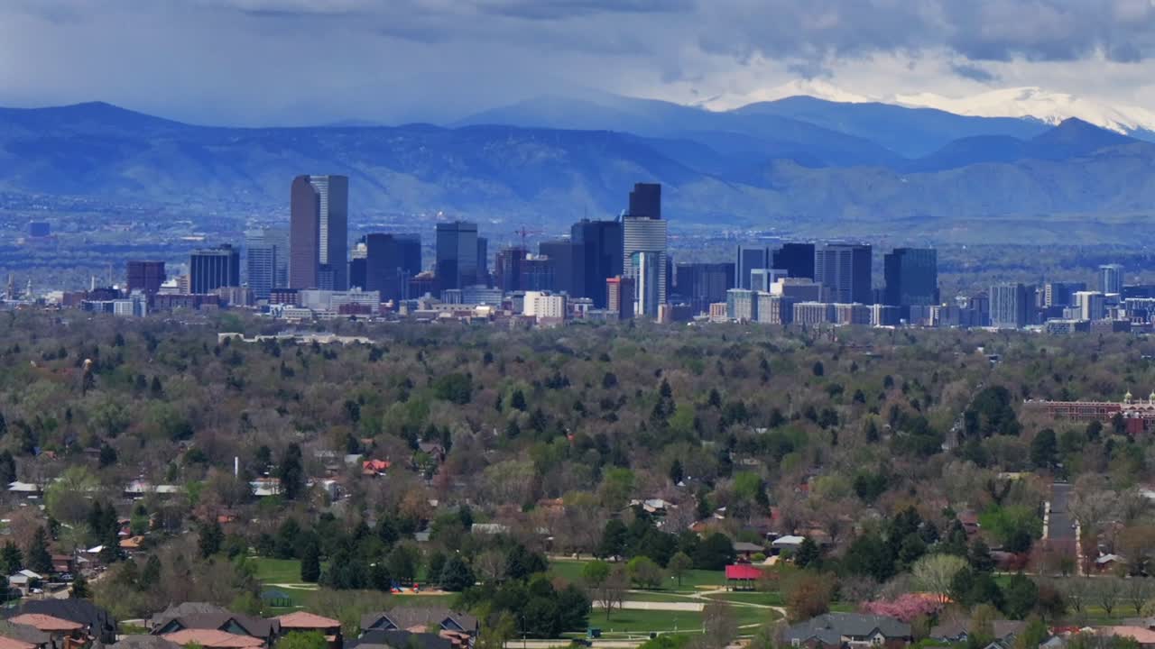 Downtown Denver skyscraper front range foothills landscape view aerial drone Colorado Northfield Stapleton Central Park spring morning rain clouds sun cityscape Capitol building forward pan up motion