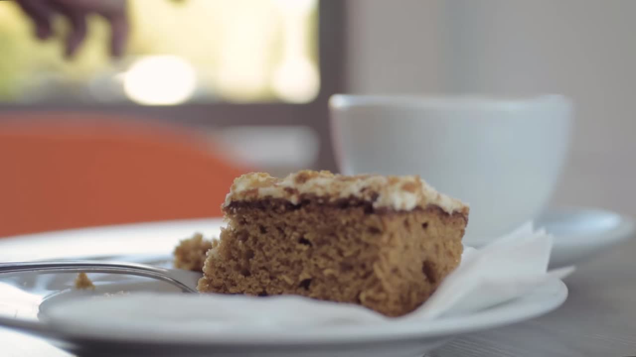 cena en la cafetería disfrutando de una taza de café y pastel de zanahoria.
