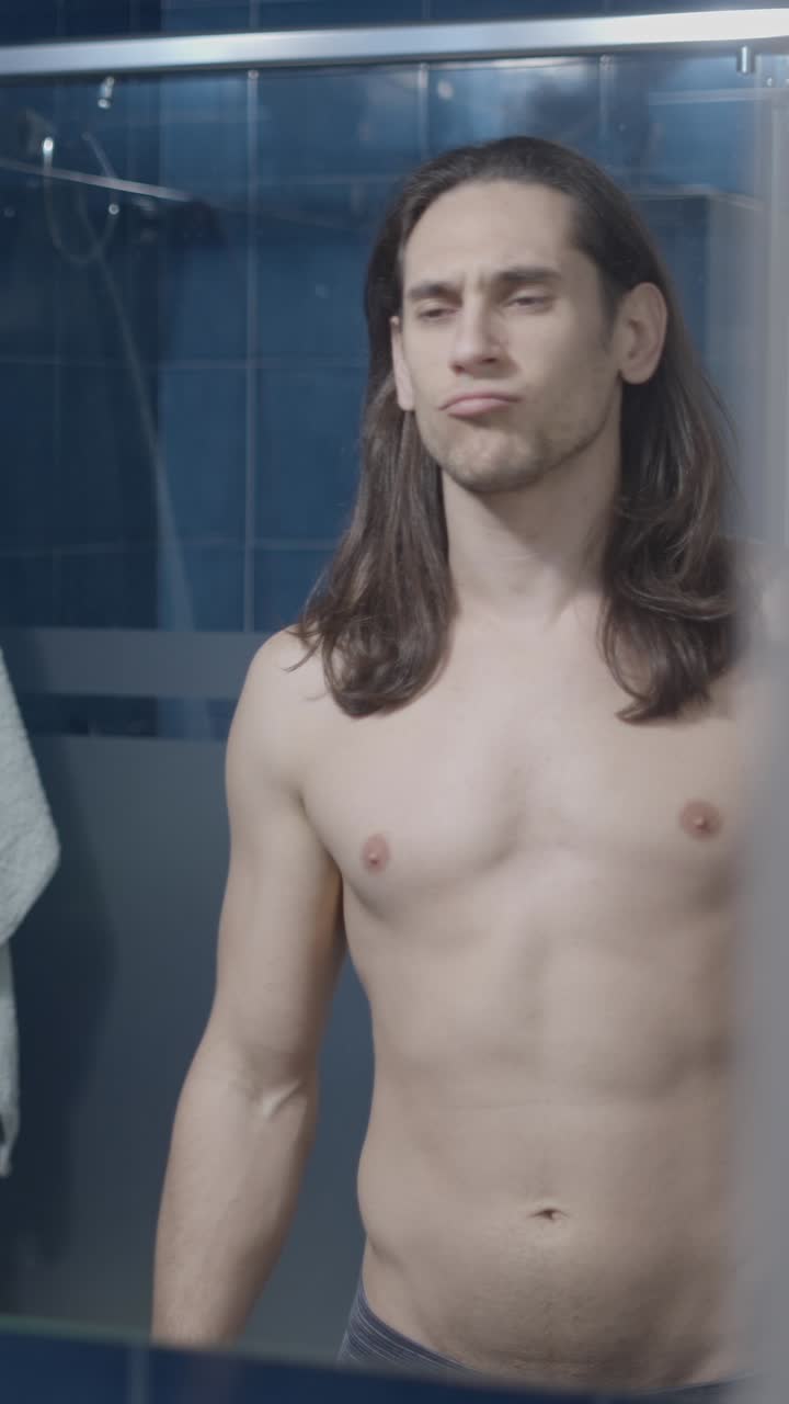 Man Flexing Bicep and Checking His Physique in the Mirror