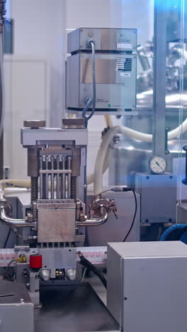process of production pills. pharmaceutical worker operates packaging machine. vertical video