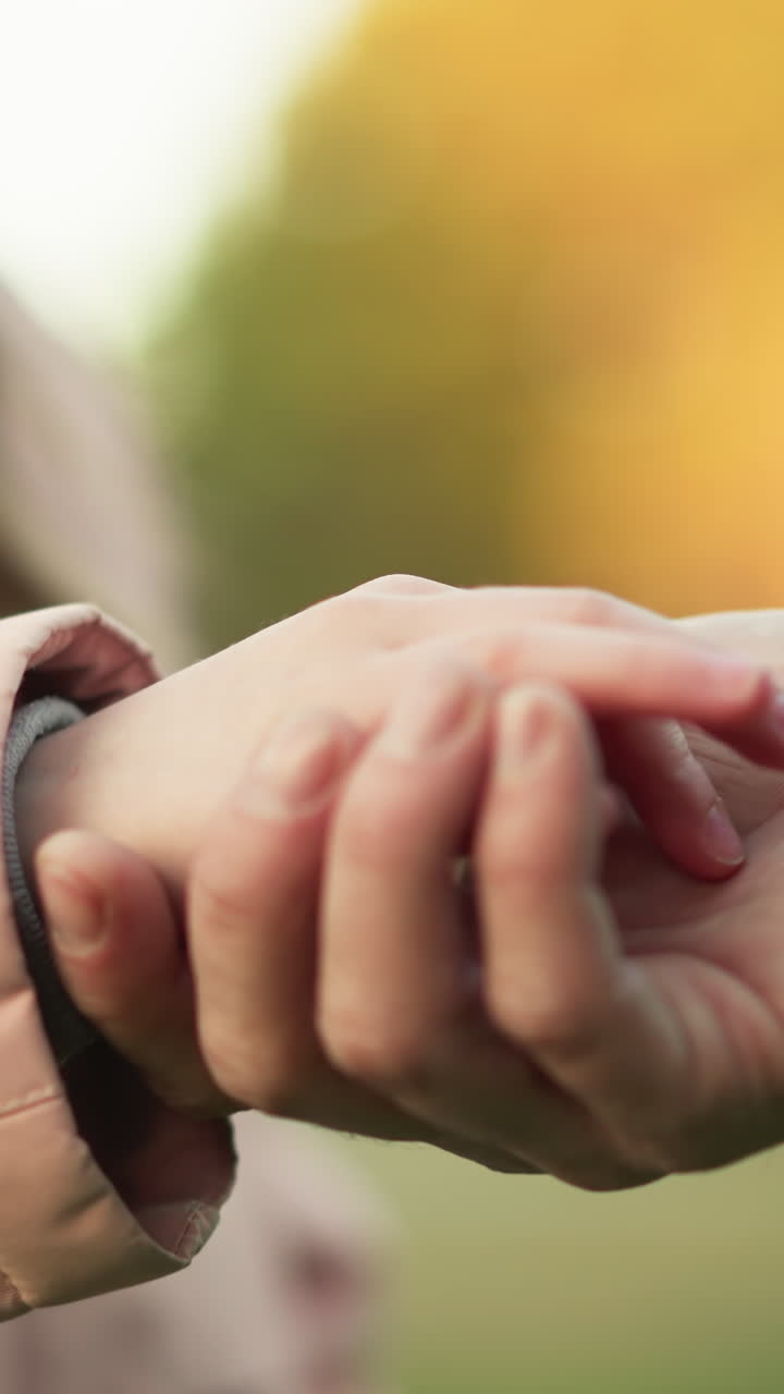 친절하고 부드러운 순간의 클로즈업, 아이가 성인의 손에 손을 고, 연결, 신뢰, 따뜻함을 상징합니다.