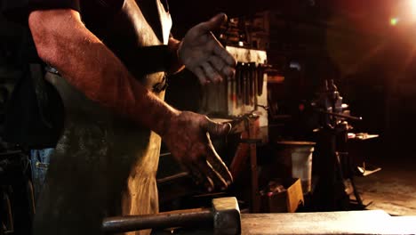 Mid-section-of-blacksmith-rubbing-his-hands