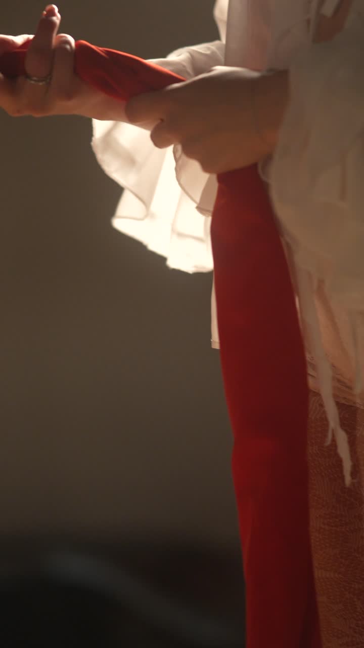 Modella con abito di pizzo bianco e sciarpa rossa