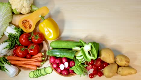 hand rearranging fresh vegetables on wooden surface