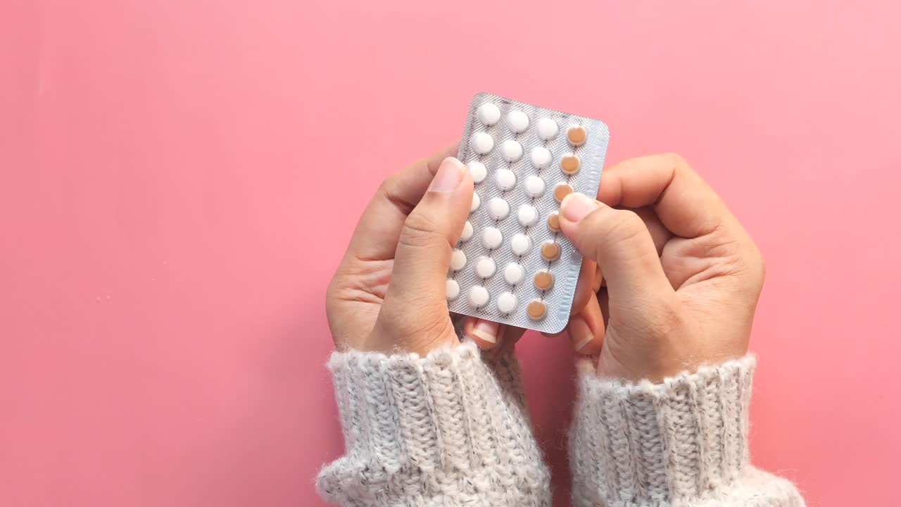 Mujer sosteniendo píldoras anticonceptivas