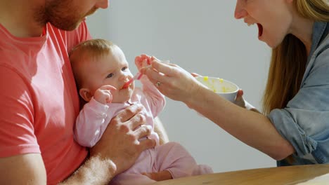 Parents-feeding-their-baby-boy-at-home-4k