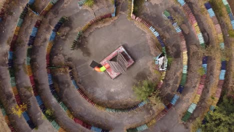 vista aérea descendente circular sobre un colorido laberinto con estructura central de madera en el parque infantil