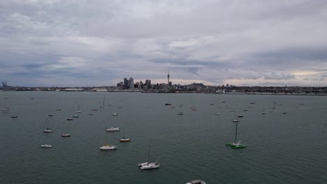 aerial footage over the waitemata harbour with the city skyline of auckland in new zealand with yachts in the foreground