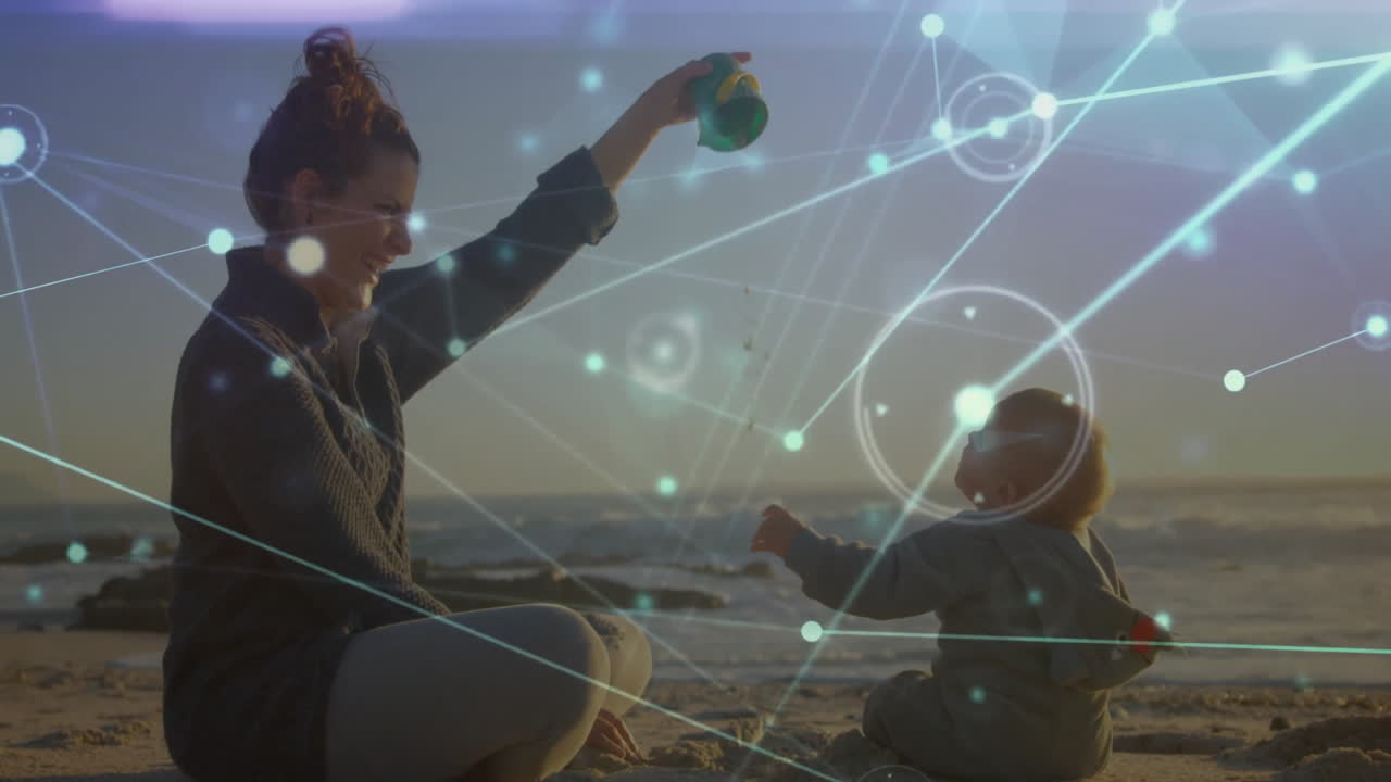 Mother and baby playing on beach with network connections animation overlay
