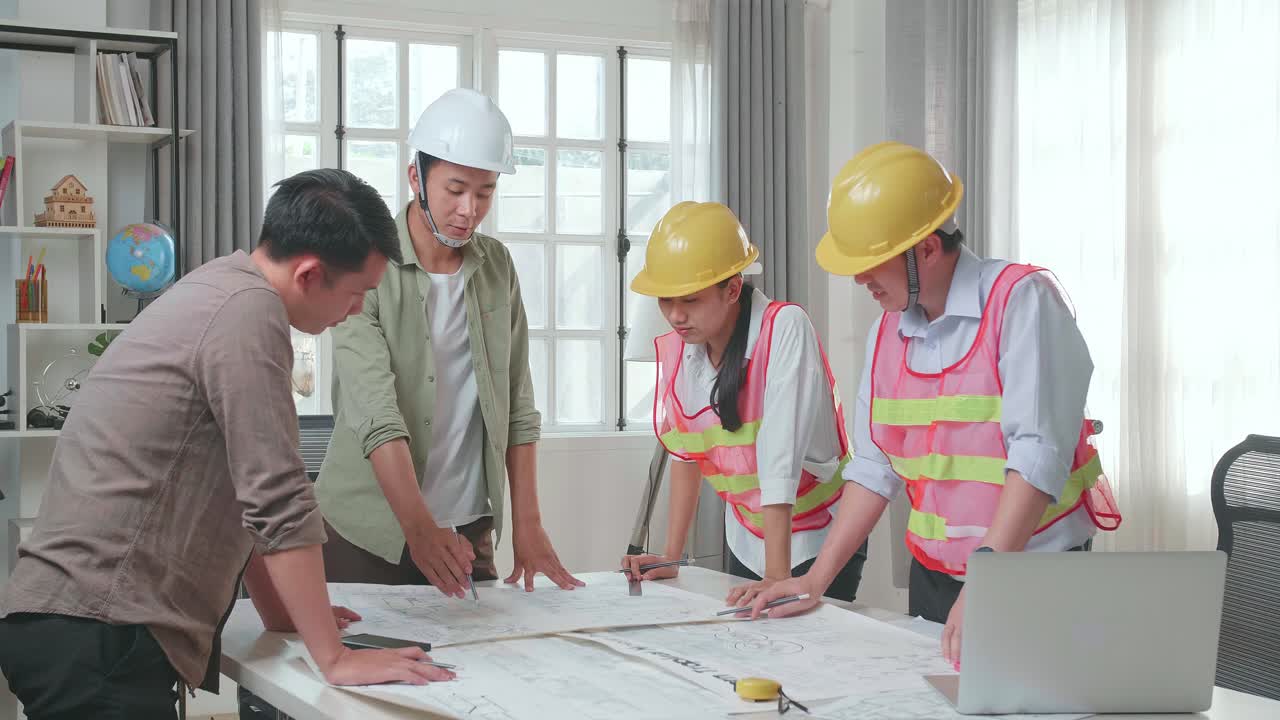 Three Asian Engineers With Helmets Presenting Work To A Man At The Office