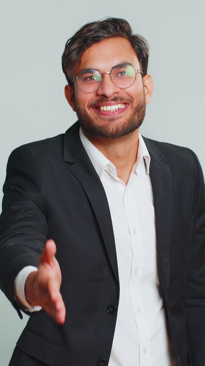 Joven indio extendiendo la mano a la cámara ofreciendo un apretón de mano saludando invitación de bienvenida