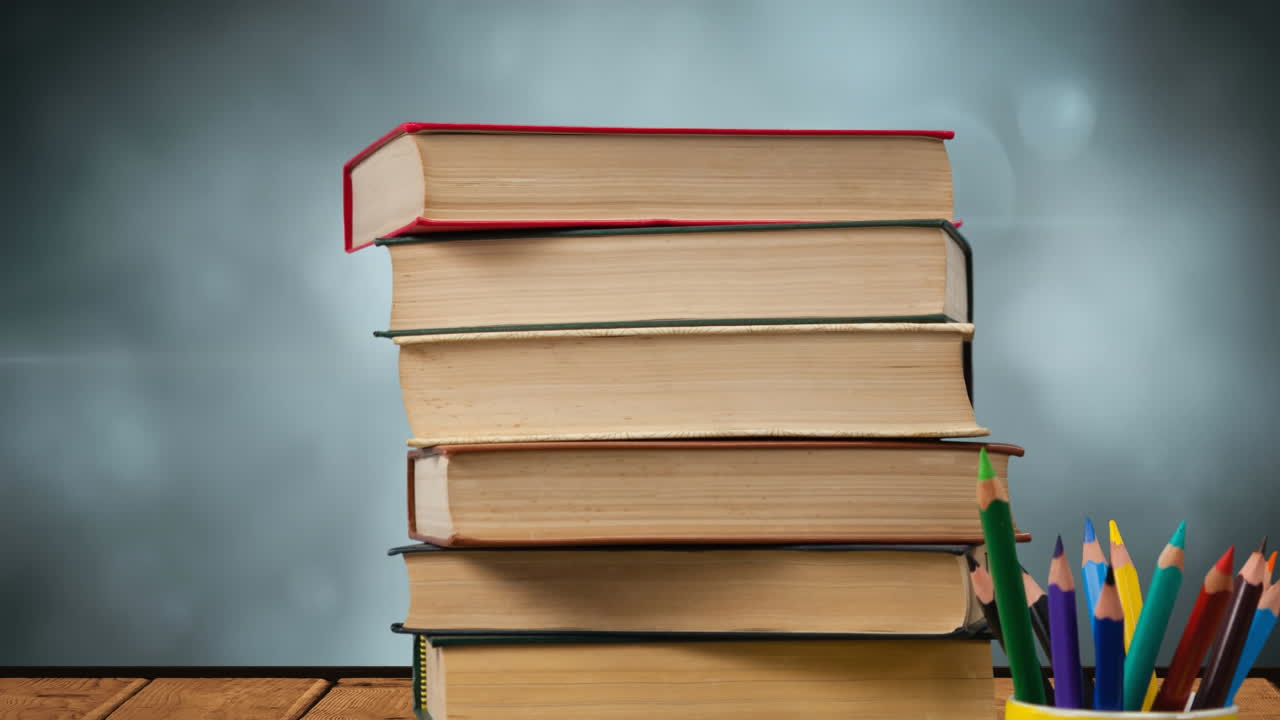 animación de una pila de libros junto a una taza con lápices de colores sobre luces brillantes