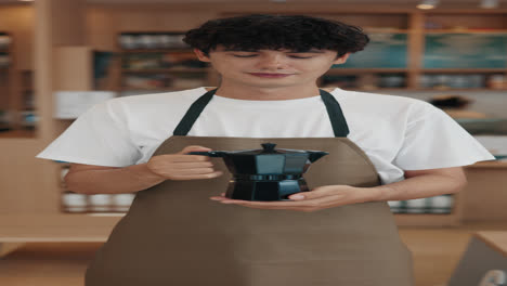 a barista holding a moka pot in a cafe