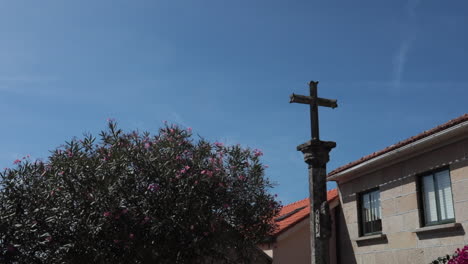 stone cross under a bright blue sky in a quiet village in pontevedra, galicia, spain