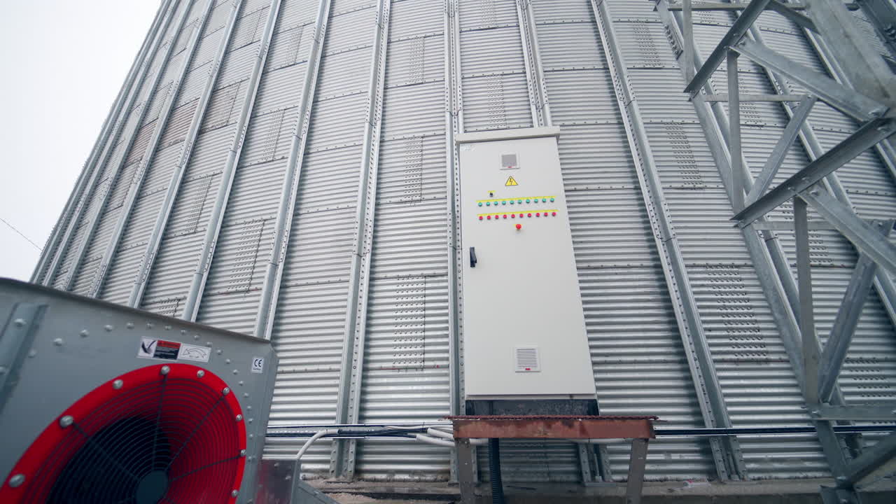 Big factory cistern exterior construction. Huge modern elevator premises with big ventilators. Circle view with approximation to a locker with buttons.