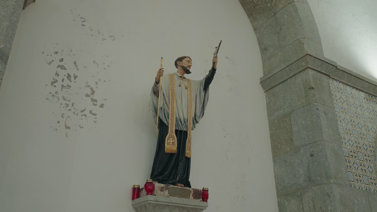 estatua religiosa ornamentada sobre la pared de una iglesia con luz interior suave