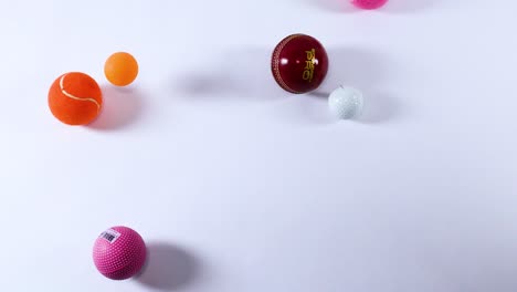 various balls moving across a white background