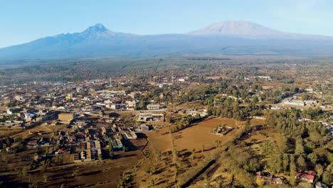 Sonnenaufgang-–-Kenia-Landschaft-Mit-Einem-Dorf,-Kilimandscharo-Und-Amboseli-Nationalpark-–-Verfolgung,-Drohnen-Luftaufnahme