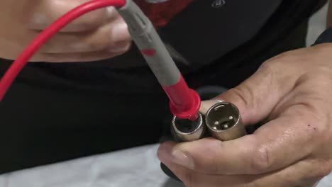 a person checks contacts and wiring of pro-audio xlr cables for audio connection of microphones, amplifiers, instruments, speakers, and much more