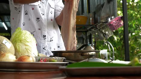 Drying-freshly-boiled-pork-belly-meat-in-garden-kitchen