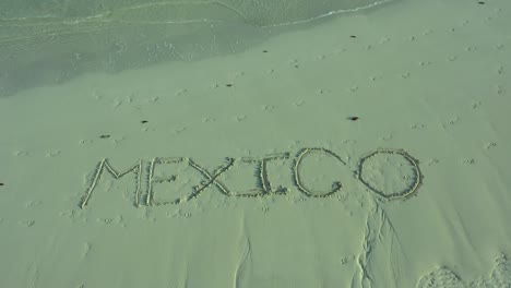 tiro giratorio de méxico inscrito en la arena de una playa