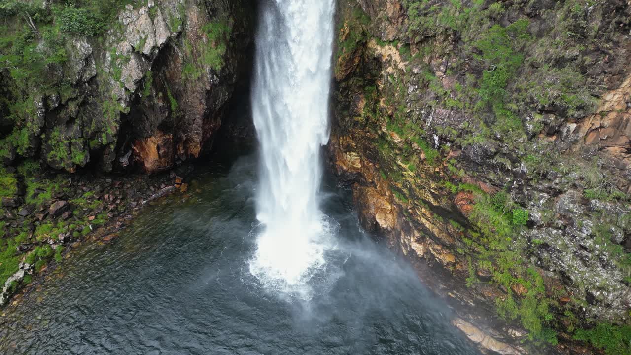 Fundao waterfall drops vertically into shallow pool below, aerial